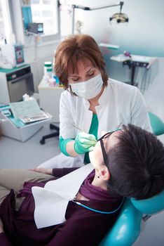 Closeup of a woman patient at the dentist waiting to be checked up with the woman doctor in the background