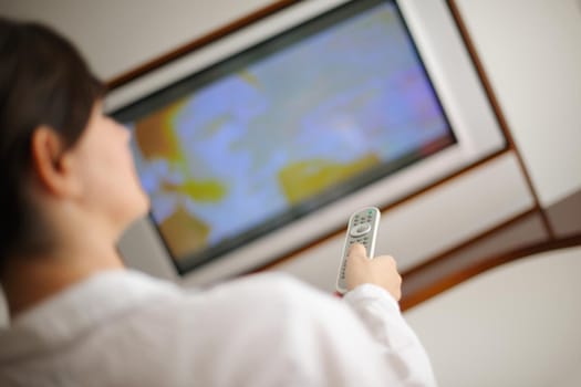 happy young woman relax at home on sofa in bright living room and watching tv