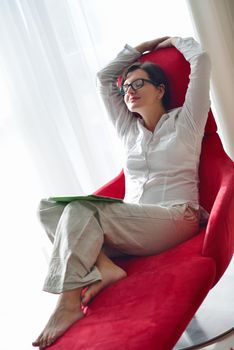 Young woman at home relaxing in her lliving room reading a digital tablet PC surf internet and work