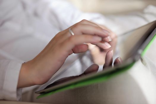 Young woman at home relaxing in her lliving room reading a digital tablet PC surf internet and work