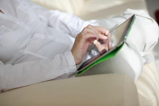 Young woman at home relaxing in her lliving room reading a digital tablet PC surf internet and work