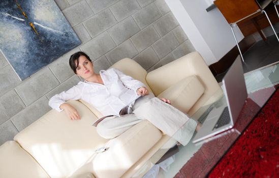 happpy young woman reading magazina at home in comfortabel sofa and bright living room