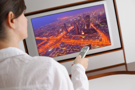 happy young woman watching tv at modern home livingroom