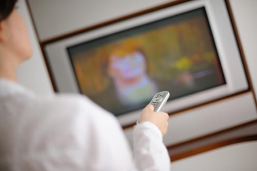 happy young woman relax at home on sofa in bright living room and watching tv