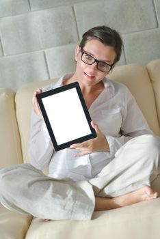 Young woman at home relaxing in her lliving room reading a digital tablet PC surf internet and work