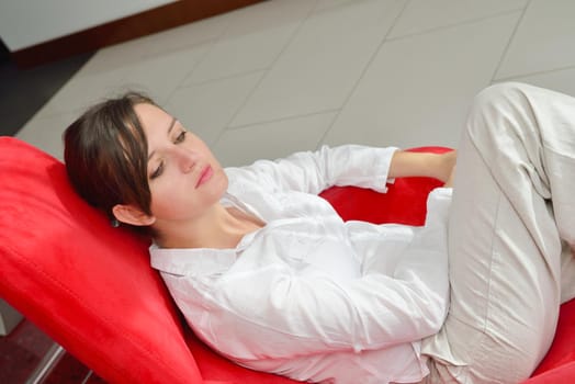 happy young woman relax at home on sofa in bright living room and watching tv