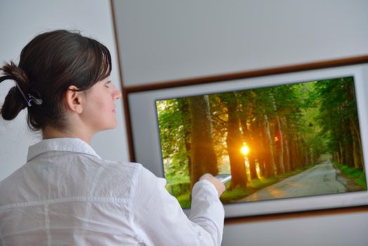 happy young woman watching tv at modern home livingroom