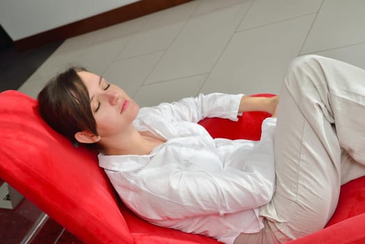 happy young woman relax at home on sofa in bright living room and watching tv