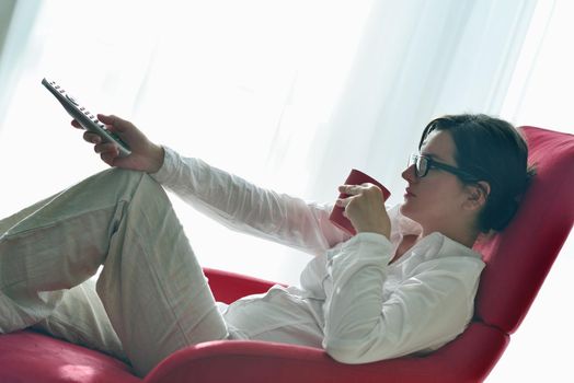 happy young woman watching tv at modern home livingroom