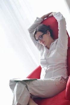 Young woman at home relaxing in her lliving room reading a digital tablet PC surf internet and work