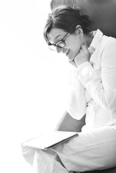 Young woman at home relaxing in her lliving room reading a digital tablet PC surf internet and work