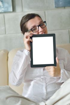 Young woman at home relaxing in her lliving room reading a digital tablet PC surf internet and work