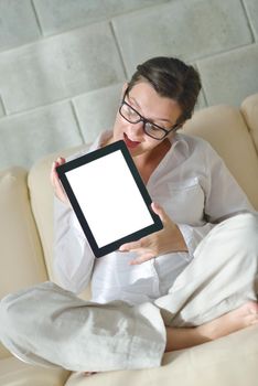 Young woman at home relaxing in her lliving room reading a digital tablet PC surf internet and work