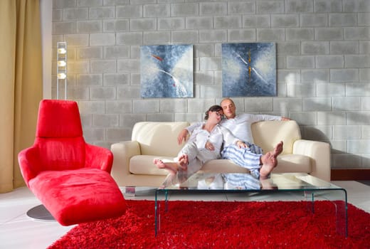 Relaxed young  couple watching tv at home in bright living room