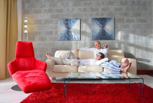 Relaxed young  couple watching tv at home in bright living room