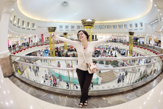 happy young woman shopping in big modern city mall