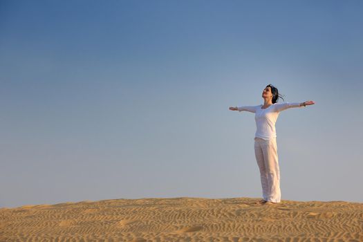 happy young woman relax and exercise yoga at desert in sunset