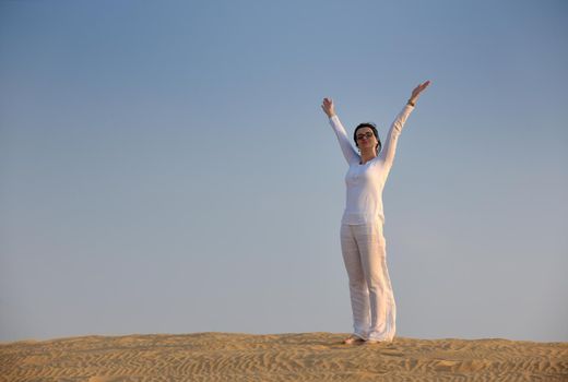 happy young woman relax and exercise yoga at desert in sunset