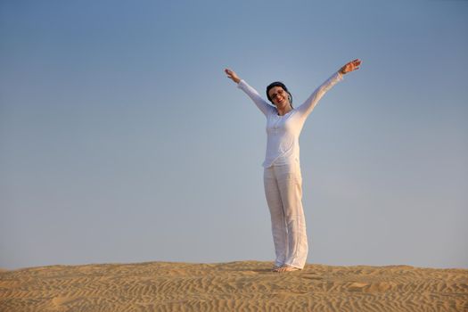 happy young woman relax and exercise yoga at desert in sunset