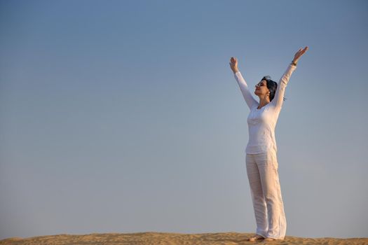 happy young woman relax and exercise yoga at desert in sunset