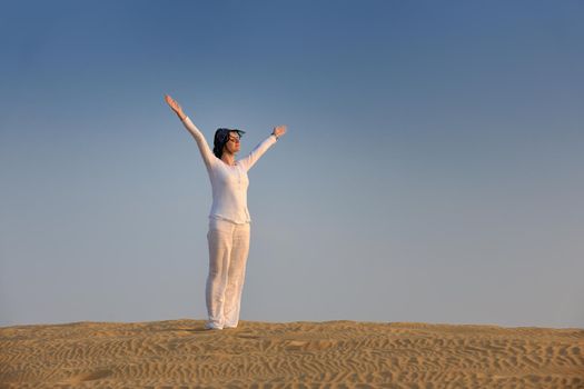 happy young woman relax and exercise yoga at desert in sunset