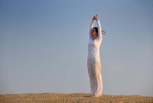 happy young woman relax and exercise yoga at desert in sunset