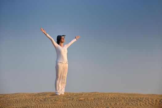 happy young woman relax and exercise yoga at desert in sunset