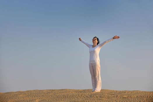 happy young woman relax and exercise yoga at desert in sunset