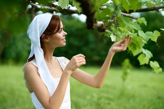 Woman in white dress in the village outdoors Green grass Farmer. High quality photo