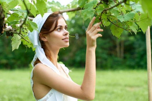 Woman in white dress in the village outdoors Green grass Farmer. High quality photo