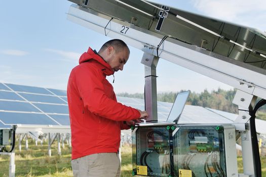 business man  engineer using laptop at solar panels plant eco energy field  in background