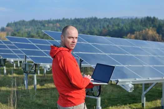 business man  engineer using laptop at solar panels plant eco energy field  in background