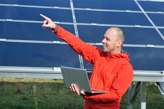 business man  engineer using laptop at solar panels plant eco energy field  in background