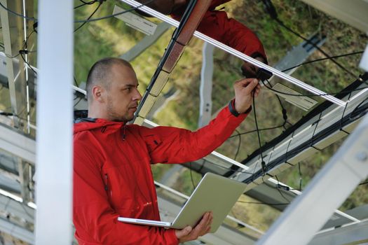 business man  engineer using laptop at solar panels plant eco energy field  in background