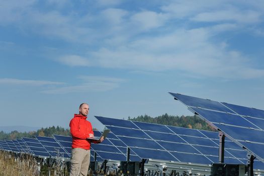 business man  engineer using laptop at solar panels plant eco energy field  in background