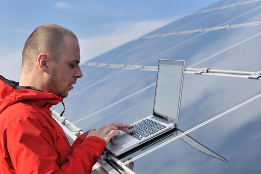 business man  engineer using laptop at solar panels plant eco energy field  in background