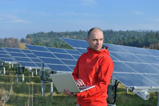 business man  engineer using laptop at solar panels plant eco energy field  in background