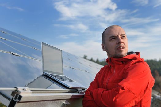 business man  engineer using laptop at solar panels plant eco energy field  in background