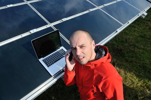 business man  engineer using laptop at solar panels plant eco energy field  in background