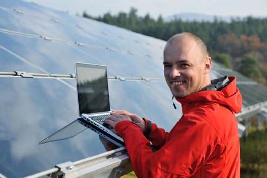 business man  engineer using laptop at solar panels plant eco energy field  in background