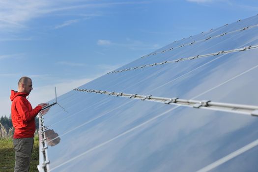 business man  engineer using laptop at solar panels plant eco energy field  in background