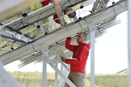 business man  engineer using laptop at solar panels plant eco energy field  in background