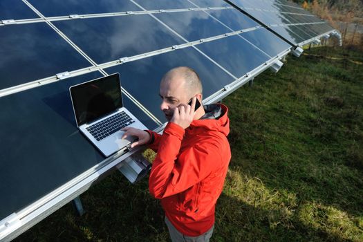 business man  engineer using laptop at solar panels plant eco energy field  in background