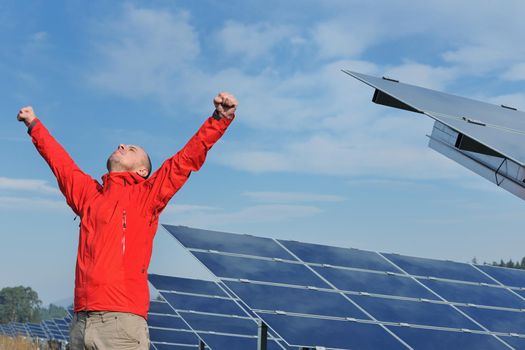 Male engineer at work place, solar panels plant industy in background