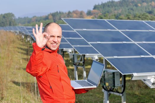 business man  engineer using laptop at solar panels plant eco energy field  in background