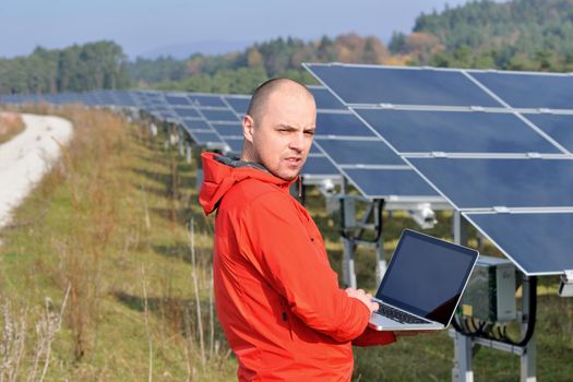 business man  engineer using laptop at solar panels plant eco energy field  in background