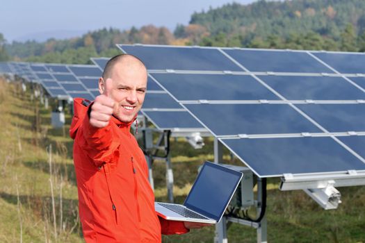 business man  engineer using laptop at solar panels plant eco energy field  in background