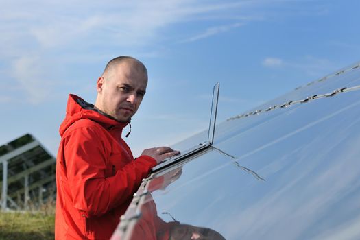 business man  engineer using laptop at solar panels plant eco energy field  in background