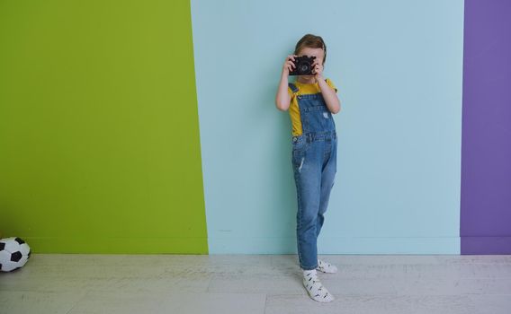 Cute little girl taking picture using vintage old retro film photo camera