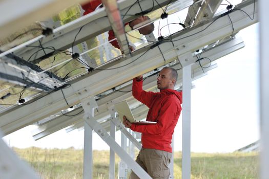 business man  engineer using laptop at solar panels plant eco energy field  in background